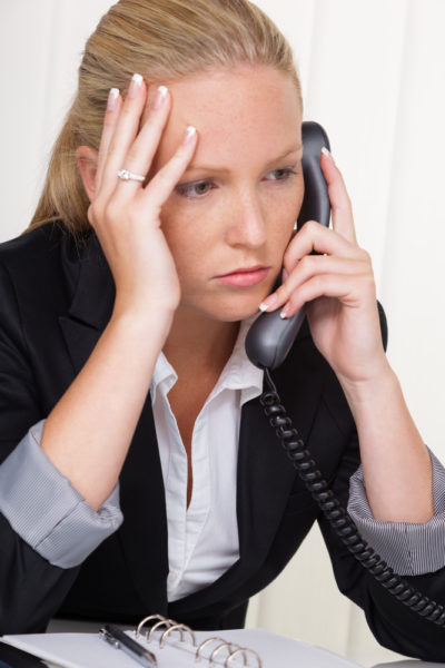 frustrated woman with phone in office